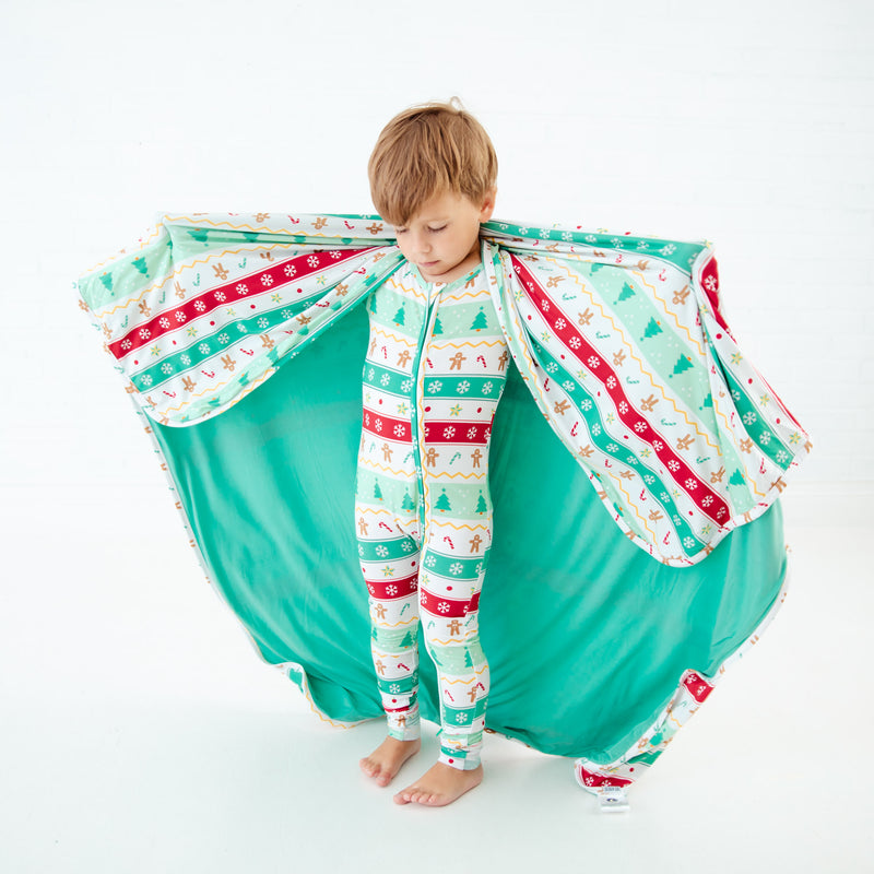 Child wearing a blanket like a cape.
