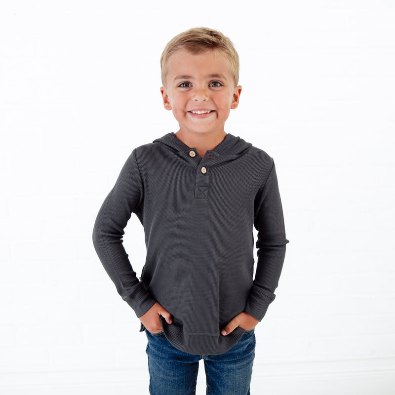 Boy wearing a grey waffle knit hoodie.