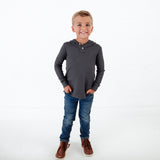 Boy wearing jeans and a grey hoodie shirt. 