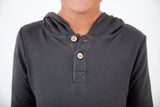 Close-up of button detail on a grey boys shirt. 