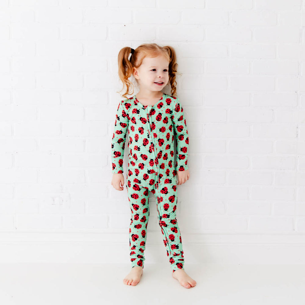Baby footie with ladybug design worn by toddler, from Dreamiere