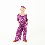 Girl wearing purple floral bamboo romper.