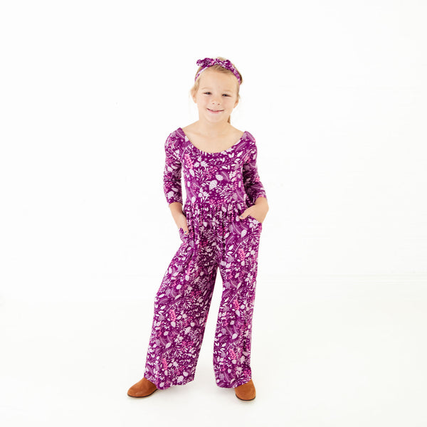 Girl wearing purple floral bamboo romper.