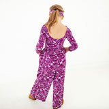 Girl showing the back of a floral romper.
