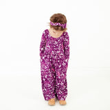 Little girl wearing purple floral headband.