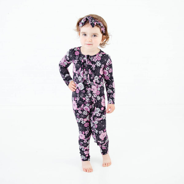 Toddler in spooky Halloween floral zipper pajamas.