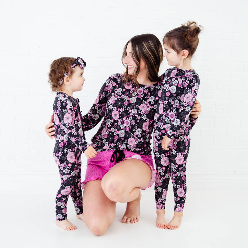 Woman and daughters wearing matching Halloween Pajamas.