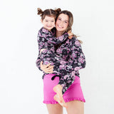 Mom and daughter wearing matching Halloween pjs.