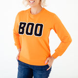 Orange BOO sweatshirt on woman. 