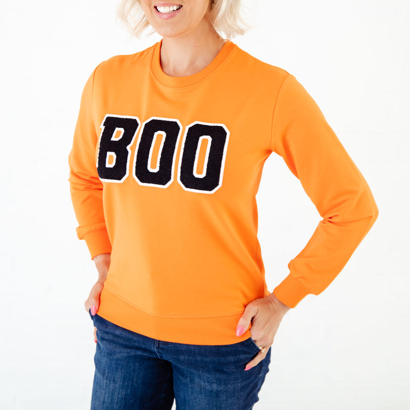 Orange BOO sweatshirt on woman. 