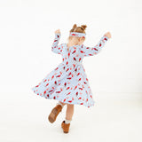 Girl spinning around in a cardinal print dress. 
