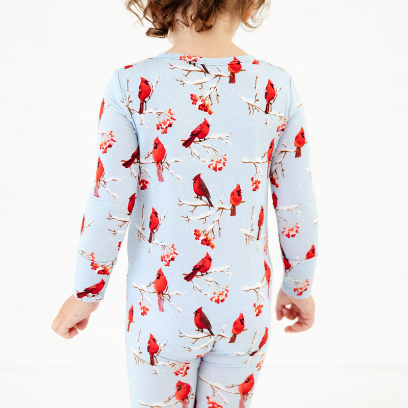Child wearing winter cardinal scene pjs.