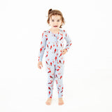 Child wearing cardinal print footed pajamas.