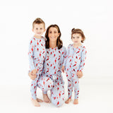 Woman and 2 children wearing matching cardinal print pajamas.