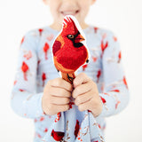 Child holding an embroidered cardinal on a child's lovey. 