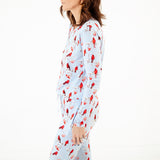 Woman wearing a long-sleeve pajama top with cardinal bird pattern.
