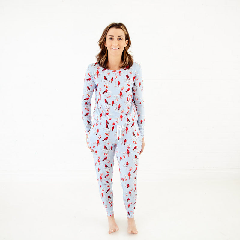 Woman wearing blue pajamas with cardinals. 