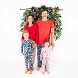 Family of four wearing coordinating Christmas Pajamas.