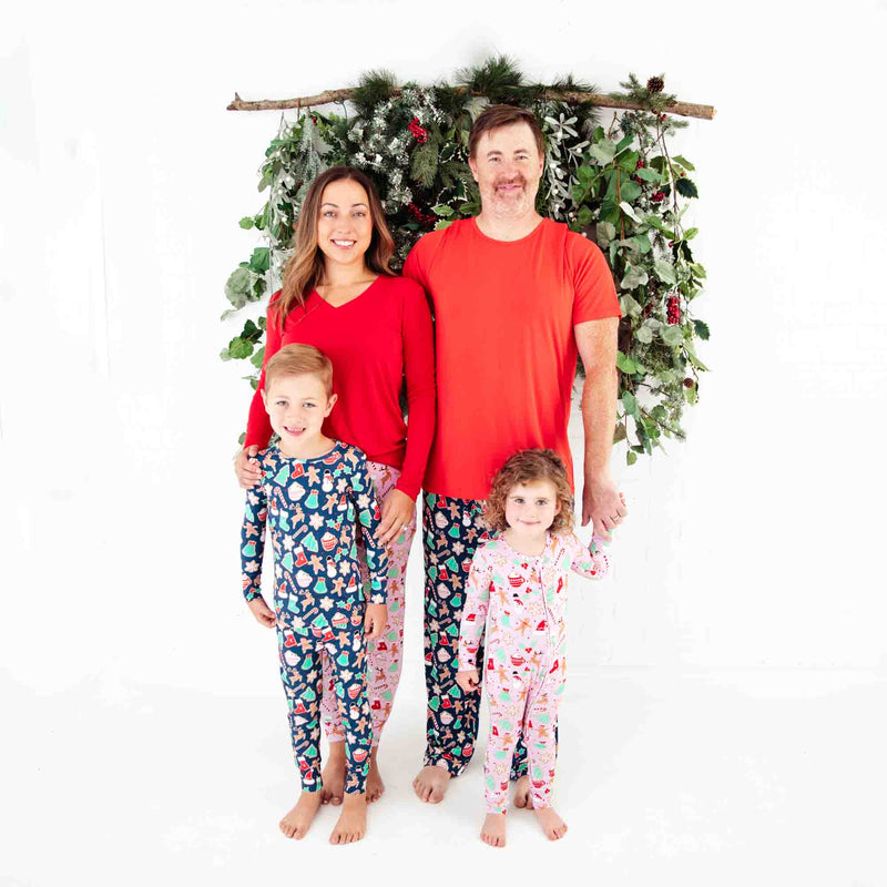 Family of four wearing coordinating Christmas Pajamas.