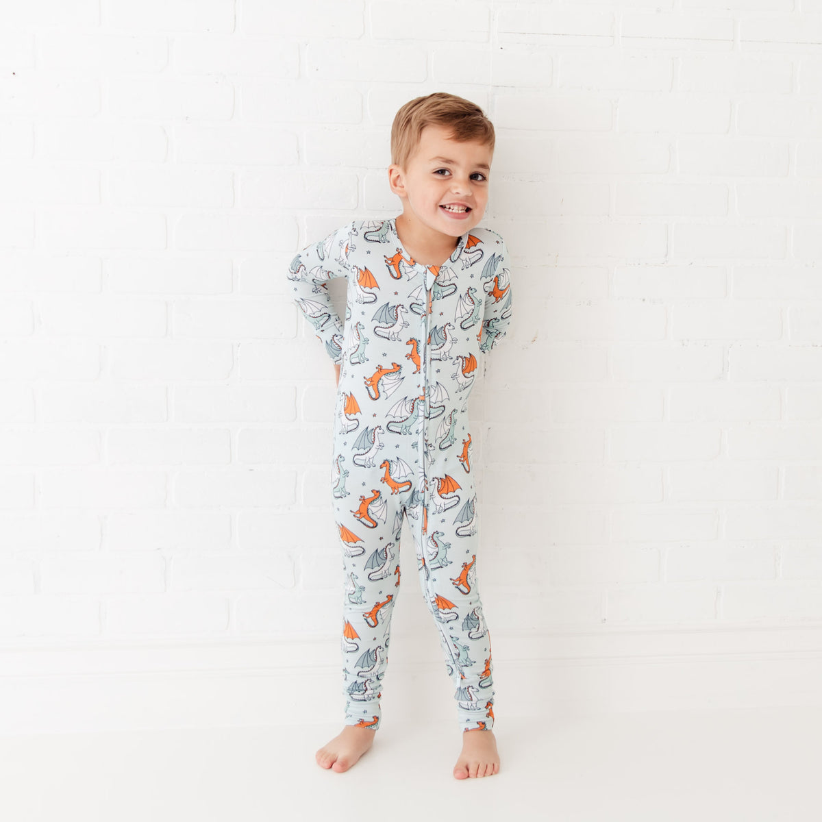 Baby footie with playful dragon print by Dreamiere