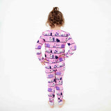 Child wearing pink halloween themed pajamas. 
