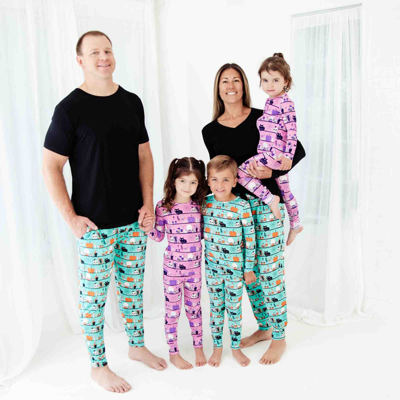 Family of five wearing matching Halloween pajamas.