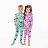 Two children wearing coordinating halloween pajamas. 