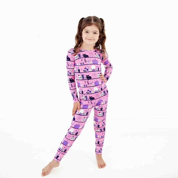 Girl wearing pink halloween themed pajamas. 