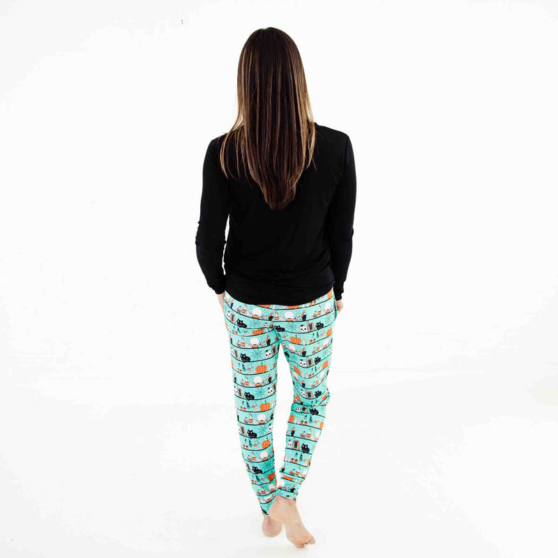 Woman wearing black shirt and halloween pajama pants. 