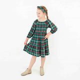 Girl wearing a holiday plaid dress.