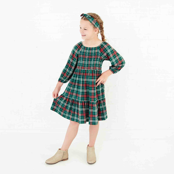Girl wearing a holiday plaid dress.
