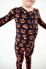 Child in halloween pumpkin pajamas. 