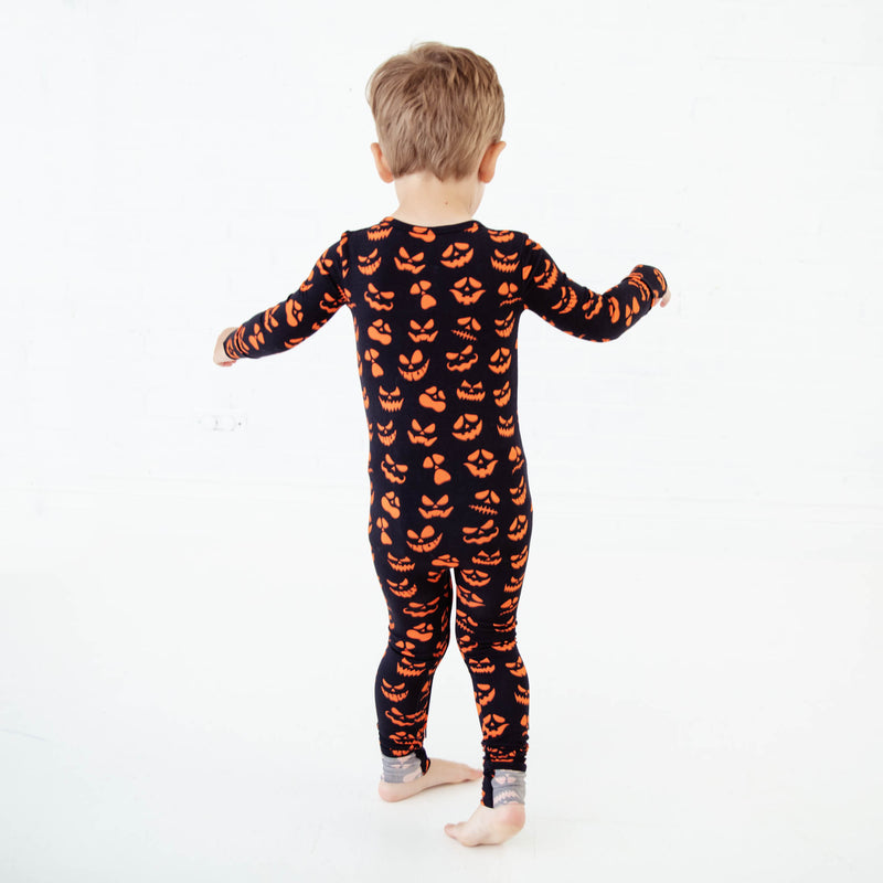 Child wearing black jack-o-lantern pajamas. 