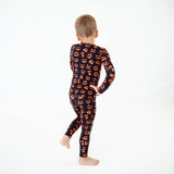 Child dancing in halloween print pajamas. 