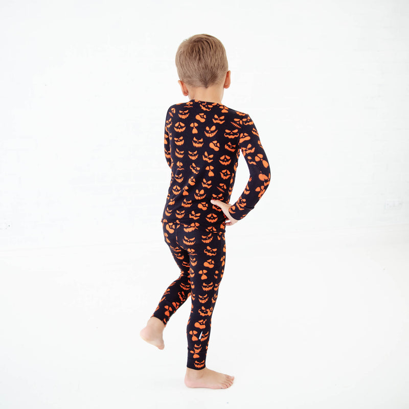 Child dancing in halloween print pajamas. 