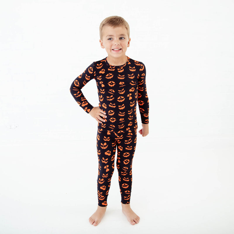 Child wearing jack-o-lantern pajamas. 