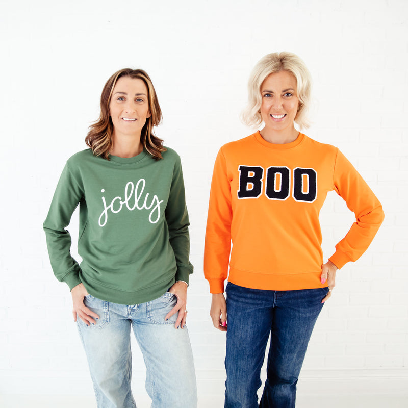 Women wearing holiday sweatshirts. 