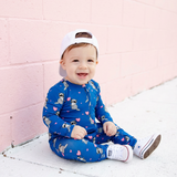 Baby sitting on a white surface with a pink wall background