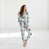 Woman wearing a patterned onesie in a bright, minimalistic room.