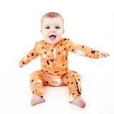 Baby wearing orange halloween themed bamboo pajamas.