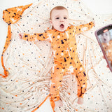 Baby laying on a blanket with stars.