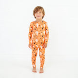 Child wearing orange halloween themed bamboo pajamas.