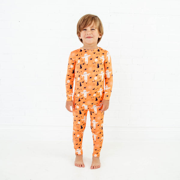 Child wearing orange halloween themed bamboo pajamas.
