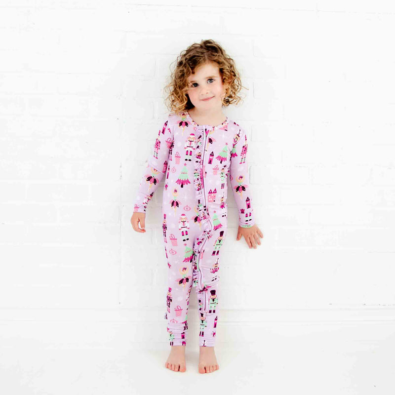 Girl wearing purple nutcracker print pajamas. 