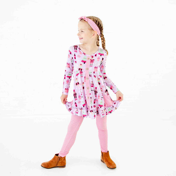 Girl wearing a nutcracker tunic set outfit. 