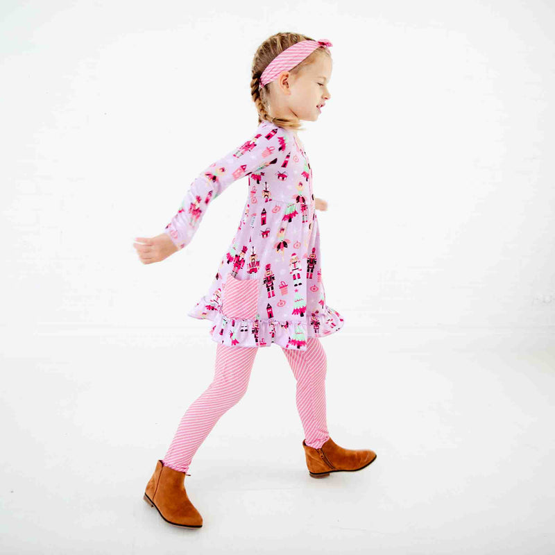 Girl dancing in nutcracker print outfit. 
