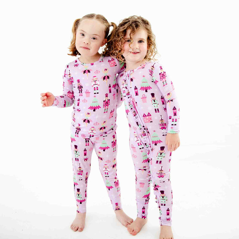 Two girls wearing matching nutcracker pajamas. 