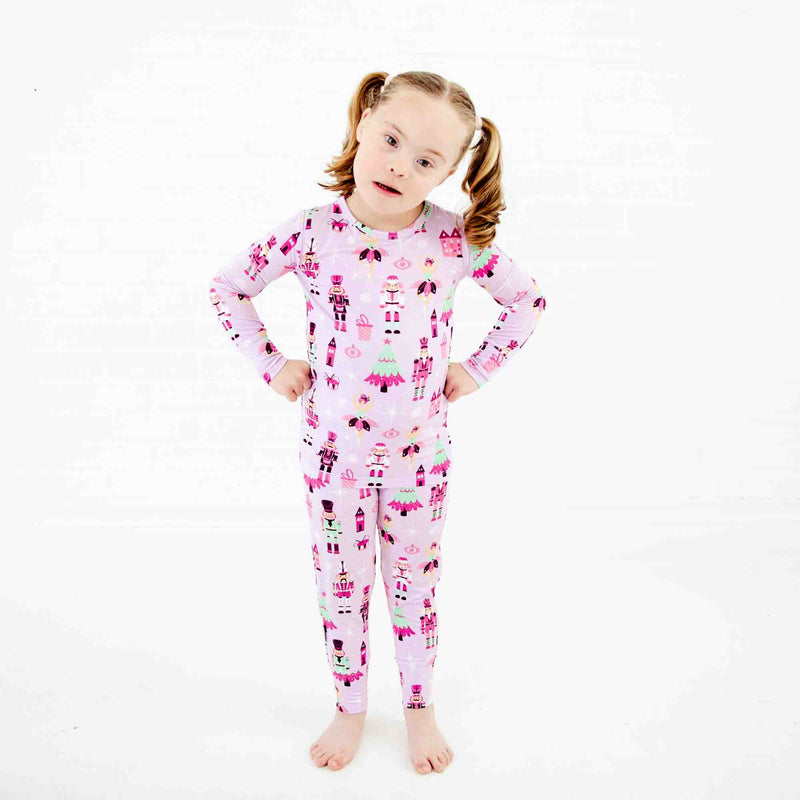 Girl wearing purple and pink nutcracker holiday pajamas. 
