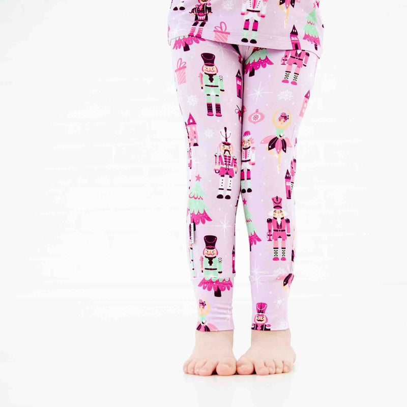 Girls legs in nutcracker print pajamas.