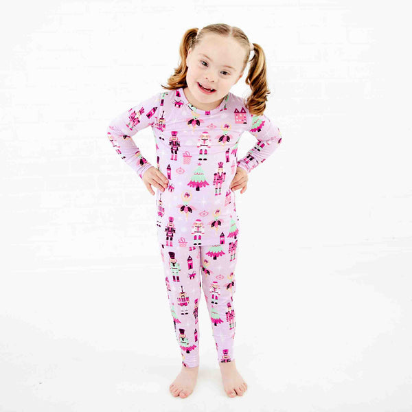 Girl wearing purple and pink nutcracker pajamas.